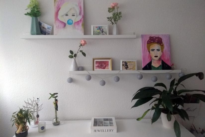 Wohnzimmerwand mit selbstgemalten Bildern